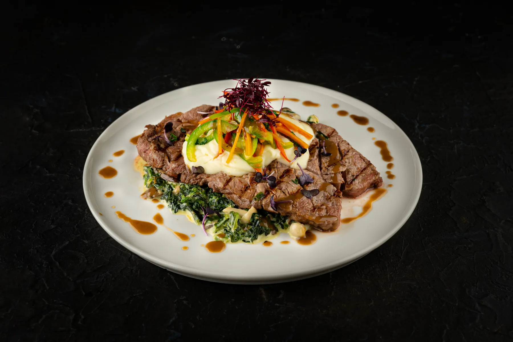 Plated steak with fresh herbs on a white plate