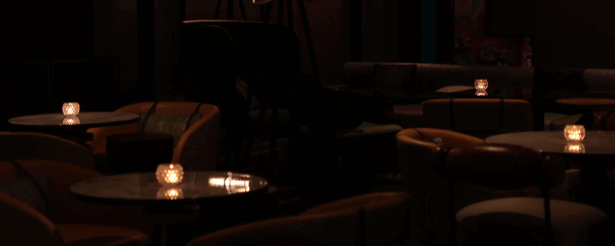 Candlelit tables in a dim dining room