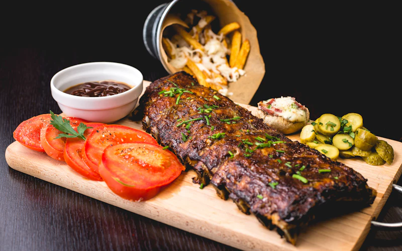 Rack of baby back ribs with fries and tomatoes