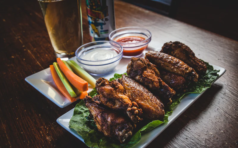 Chicken wings with dipping sauces and a cold beer