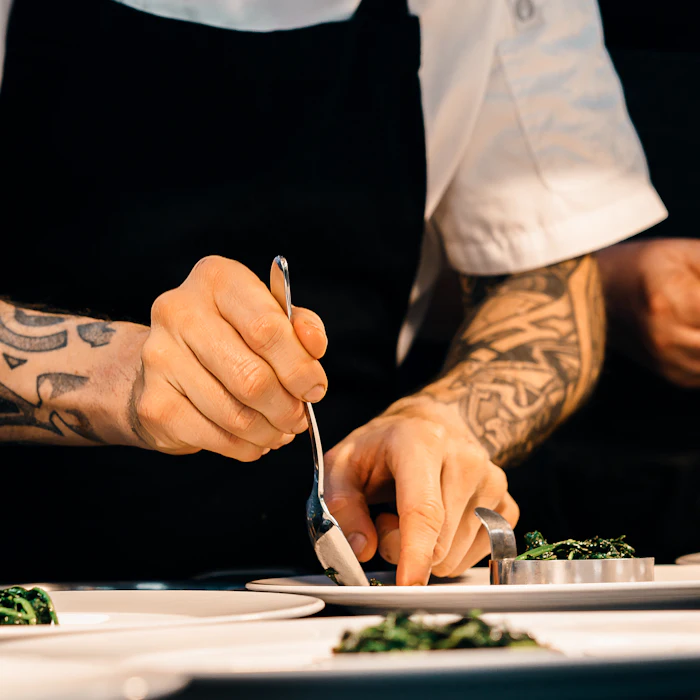 Cook plating a dish in the kitchen